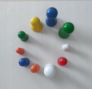 Der Kreis aus unterschiedlich farbigen  und großen Spielfiguren symbolisiert den gemeinsamen Tanz  und die gegenseitige Untersttuetzung.