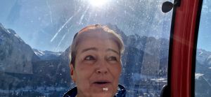 Marion sitzt in der Gondel und hinter ihr sind die Berge zu sehen